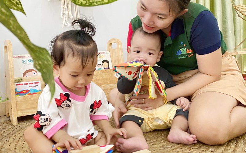 Cô ngồi cùng hai bé nhỏ, khám phá đồ chơi vải mềm